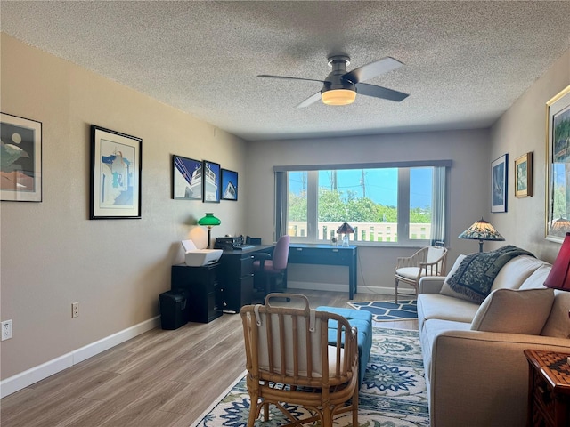 100 Bluff View Dr Unit 115C, Belleair Bluffs, FL 33770 - living area with a desk, wood finished floors, ceiling fan, and a textured ceiling