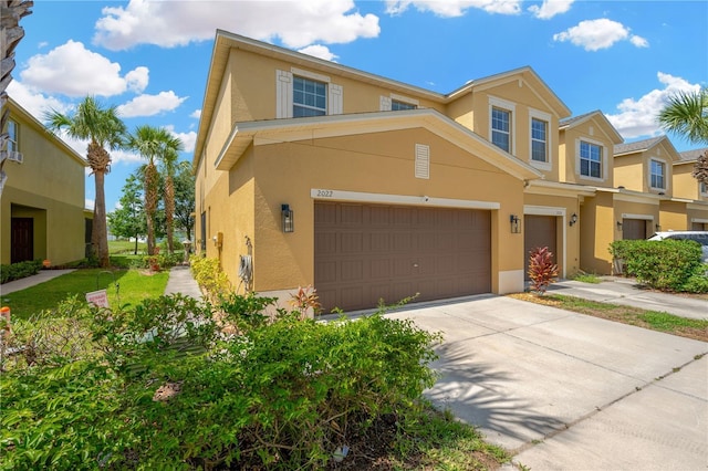 2022 Hawks View Dr, Ruskin, FL 33570 - view of front of home with stucco siding, an attached garage, and concrete driveway