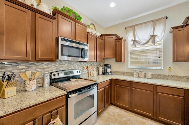 2022 Hawks View Dr, Ruskin, FL 33570 - kitchen with stainless steel appliances, tasteful backsplash, and brown cabinetry