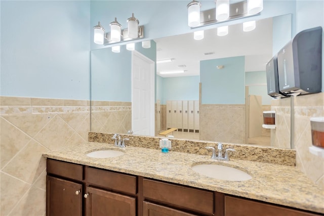 2022 Hawks View Dr, Ruskin, FL 33570 - bathroom with double vanity, tile walls, a shower, and a wainscoted wall
