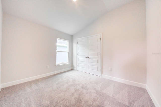 16425 66th Ln E, Parrish, FL 34219 - unfurnished bedroom with vaulted ceiling, carpet floors, baseboards, and a closet