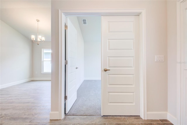 16425 66th Ln E, Parrish, FL 34219 - corridor featuring light wood-style flooring, a chandelier, and baseboards