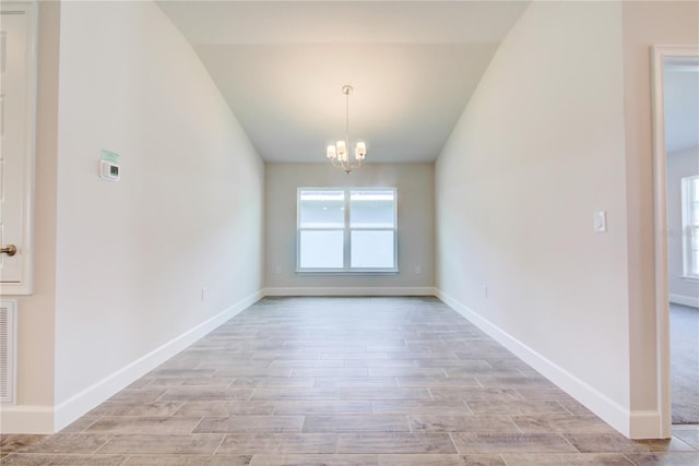 16425 66th Ln E, Parrish, FL 34219 - unfurnished dining area with lofted ceiling, a chandelier, light wood-type flooring, and baseboards