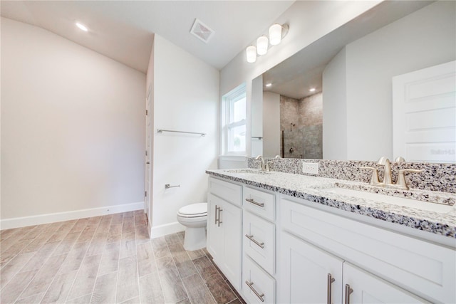 16425 66th Ln E, Parrish, FL 34219 - bathroom with double vanity, a tile shower, baseboards, toilet, and wood finished floors