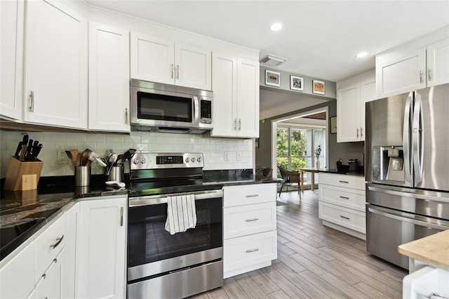 7219 4th Ave N, Saint Petersburg, FL 33710 - kitchen featuring stainless steel appliances, white cabinets, decorative backsplash, light wood-style floors, and recessed lighting