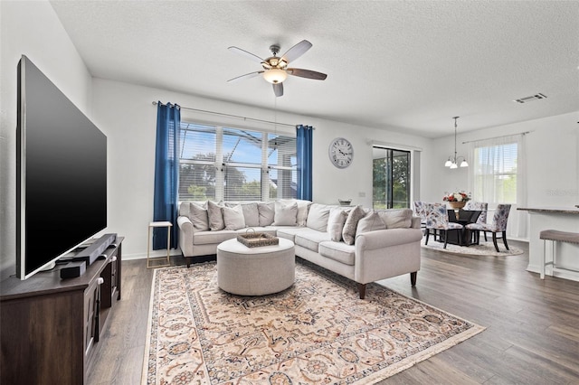 11434 Leland Groves Dr, Riverview, FL 33579 - living area featuring a textured ceiling, a ceiling fan, dark wood finished floors, and a chandelier