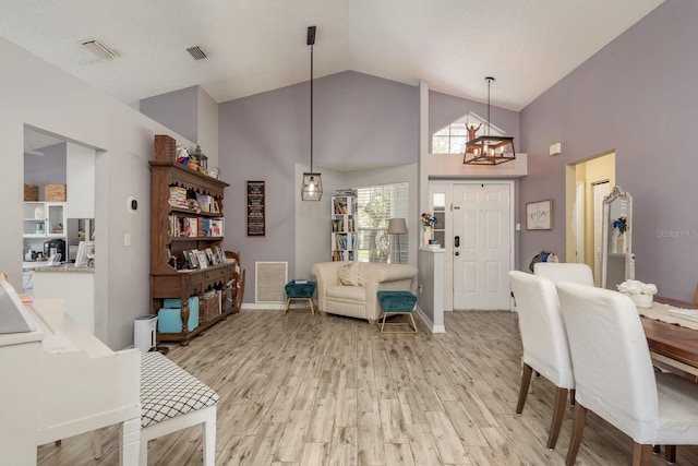 5826 Taywood Dr, Tampa, FL 33624 - dining space with high vaulted ceiling, a chandelier, light wood finished floors, and baseboards