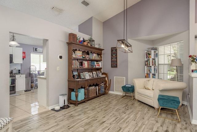 5826 Taywood Dr, Tampa, FL 33624 - living area featuring baseboards, light wood-style flooring, high vaulted ceiling, and plenty of natural light