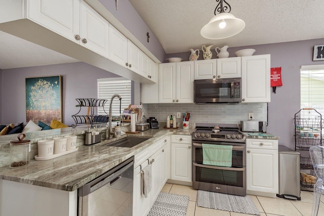 5826 Taywood Dr, Tampa, FL 33624 - kitchen featuring stainless steel appliances, a sink, white cabinetry, a peninsula, and tasteful backsplash