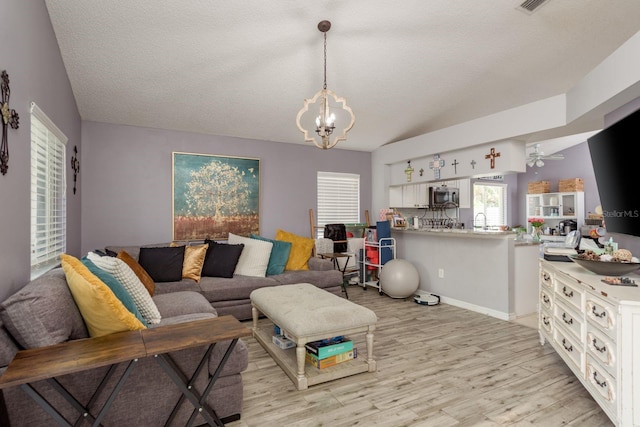 5826 Taywood Dr, Tampa, FL 33624 - living area with light wood-style flooring, a chandelier, a textured ceiling, and a ceiling fan
