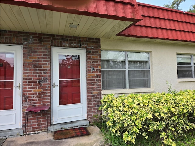 5865 37th Ave N Unit 26, Saint Petersburg, FL 33710 - view of exterior entry with brick siding, a tile roof, and stucco siding