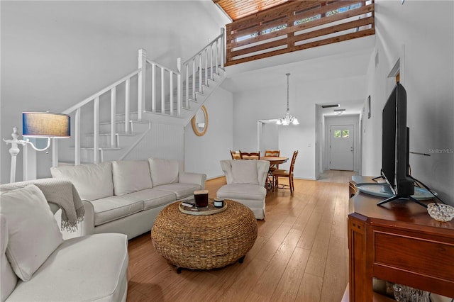 7705 4th Ave W, Bradenton, FL 34209 - living room with a towering ceiling, stairway, a chandelier, and light wood-style flooring