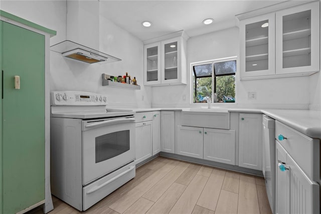 7705 4th Ave W, Bradenton, FL 34209 - kitchen featuring white appliances, light countertops, light wood finished floors, glass insert cabinets, and white cabinets