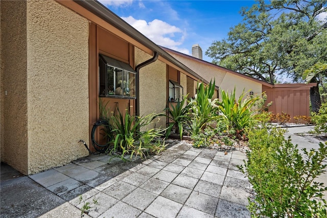 7705 4th Ave W, Bradenton, FL 34209 - view of home's exterior with stucco siding, a patio, and a chimney