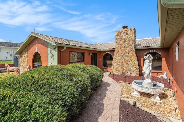 159 Canby Cir, Spring Hill, FL 34606 - rear view of property with a chimney, a tiled roof, and stucco siding
