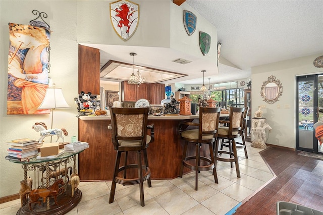 159 Canby Cir, Spring Hill, FL 34606 - bar featuring lofted ceiling, plenty of natural light, a chandelier, hanging light fixtures, and a textured ceiling