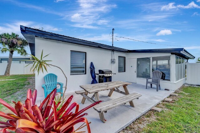551 Lindley Ter, Port Charlotte, FL 33952 - back of property with a patio area, a sunroom, and stucco siding