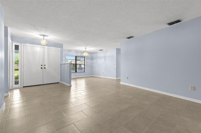 14164 Fennsbury Dr, Tampa, FL 33624 - unfurnished living room with a textured ceiling, baseboards, and tile patterned floors
