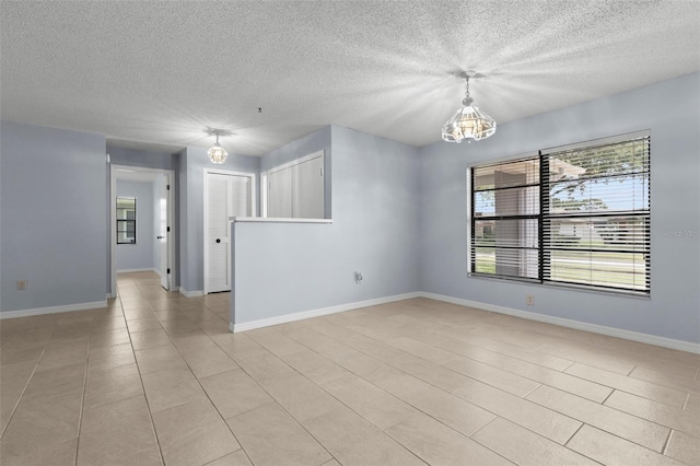 14164 Fennsbury Dr, Tampa, FL 33624 - unfurnished room with a chandelier, a textured ceiling, baseboards, and light tile patterned floors