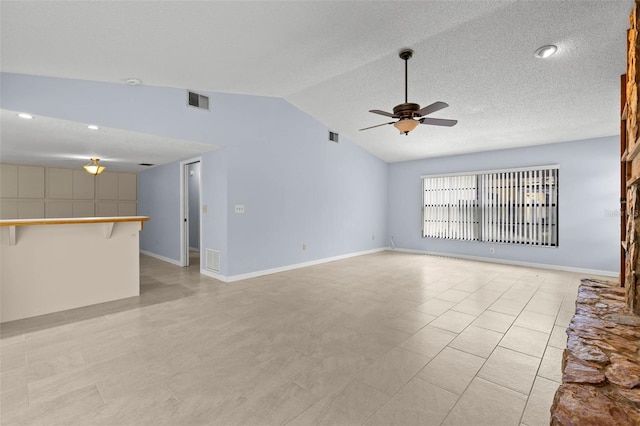 14164 Fennsbury Dr, Tampa, FL 33624 - spare room featuring a ceiling fan, lofted ceiling, baseboards, a textured ceiling, and light tile patterned flooring