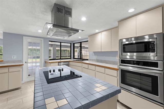 14164 Fennsbury Dr, Tampa, FL 33624 - kitchen featuring stainless steel appliances, a sink, island exhaust hood, tile countertops, and recessed lighting