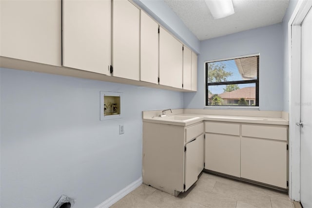 14164 Fennsbury Dr, Tampa, FL 33624 - laundry area featuring cabinet space, hookup for a washing machine, light tile patterned flooring, baseboards, and a textured ceiling