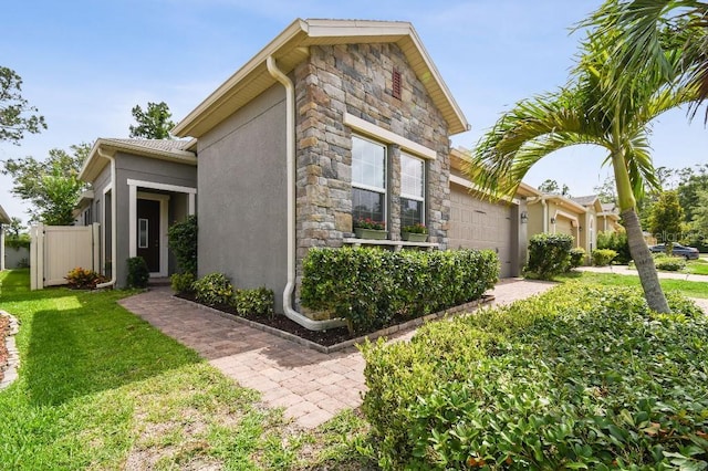 1553 Amber Leaf Cir, Ocoee, FL 34761 - view of side of property with stone siding, stucco siding, and an attached garage
