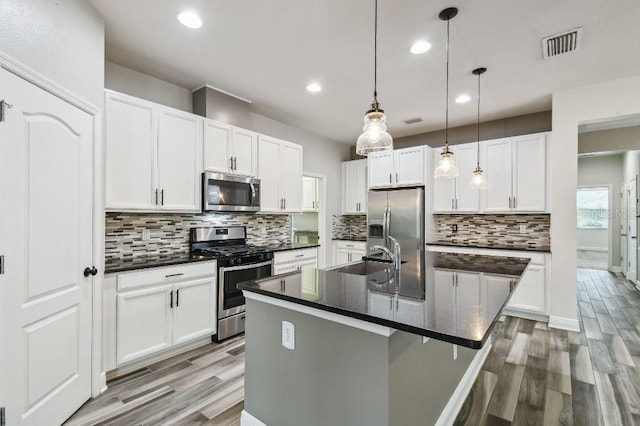 1553 Amber Leaf Cir, Ocoee, FL 34761 - kitchen featuring appliances with stainless steel finishes, a sink, light wood-style flooring, recessed lighting, and decorative backsplash
