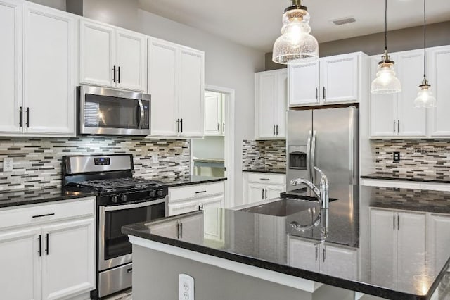 1553 Amber Leaf Cir, Ocoee, FL 34761 - kitchen featuring appliances with stainless steel finishes, tasteful backsplash, white cabinetry, and dark stone countertops