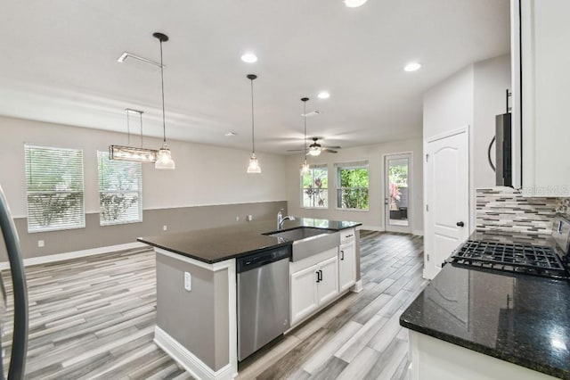 1553 Amber Leaf Cir, Ocoee, FL 34761 - kitchen with appliances with stainless steel finishes, light wood-style floors, a sink, tasteful backsplash, and white cabinets