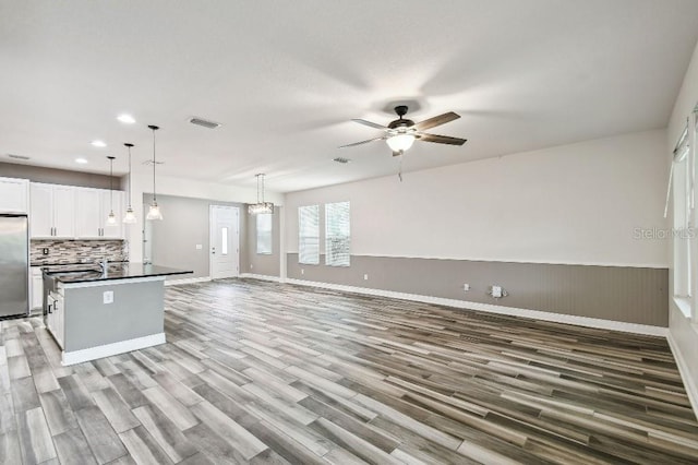 1553 Amber Leaf Cir, Ocoee, FL 34761 - kitchen featuring built in refrigerator, dark countertops, open floor plan, white cabinets, and light wood-style floors