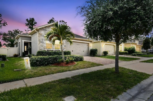 1553 Amber Leaf Cir, Ocoee, FL 34761 - view of front facade featuring stone siding, a garage, driveway, and stucco siding