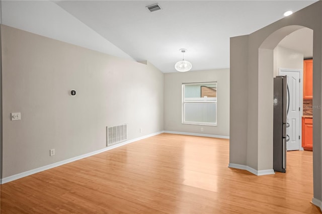 826 Addison Dr NE, Saint Petersburg, FL 33716 - empty room with light wood-style flooring, lofted ceiling, and arched walkways