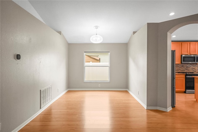 826 Addison Dr NE, Saint Petersburg, FL 33716 - unfurnished dining area featuring arched walkways, light wood-type flooring, and recessed lighting