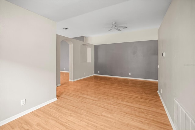 826 Addison Dr NE, Saint Petersburg, FL 33716 - empty room with a ceiling fan, light wood-type flooring, and arched walkways