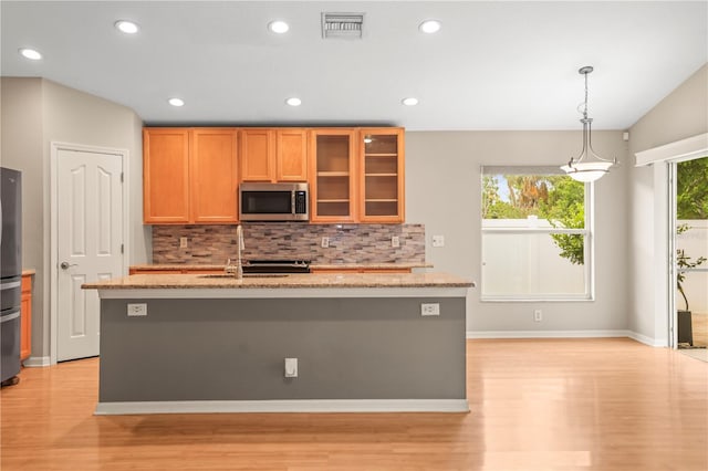 826 Addison Dr NE, Saint Petersburg, FL 33716 - kitchen featuring stainless steel appliances, light wood-style floors, decorative backsplash, light stone counters, and recessed lighting