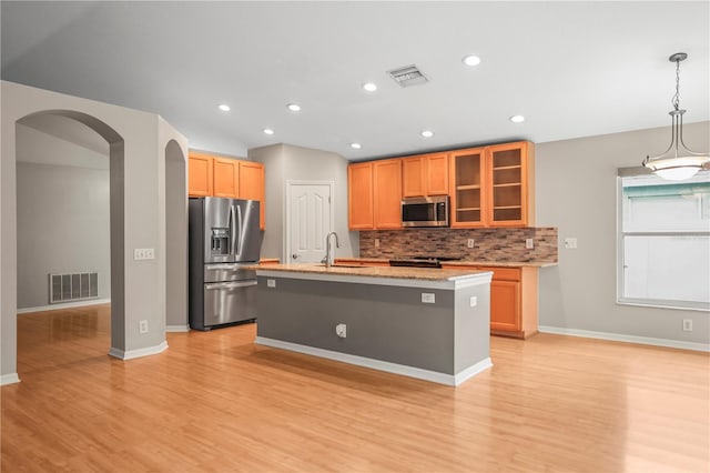 826 Addison Dr NE, Saint Petersburg, FL 33716 - kitchen with stainless steel appliances, arched walkways, light wood-style flooring, tasteful backsplash, and recessed lighting
