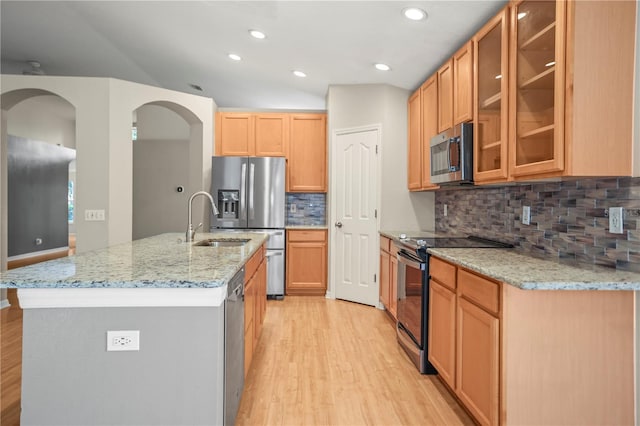 826 Addison Dr NE, Saint Petersburg, FL 33716 - kitchen with stainless steel appliances, light wood-style flooring, arched walkways, light stone counters, and recessed lighting