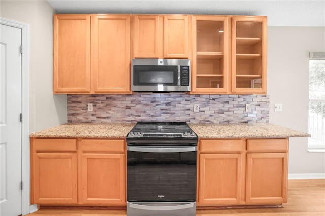 826 Addison Dr NE, Saint Petersburg, FL 33716 - kitchen with stainless steel appliances, light brown cabinets, tasteful backsplash, and light stone countertops