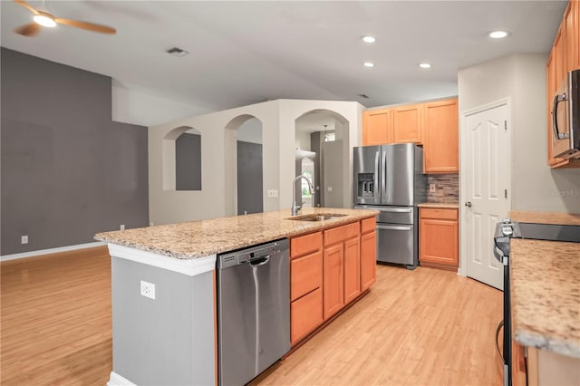 826 Addison Dr NE, Saint Petersburg, FL 33716 - kitchen with stainless steel appliances, light wood-type flooring, a kitchen island with sink, decorative backsplash, and recessed lighting