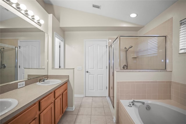 826 Addison Dr NE, Saint Petersburg, FL 33716 - bathroom featuring a shower stall, a garden tub, double vanity, tile patterned flooring, and vaulted ceiling