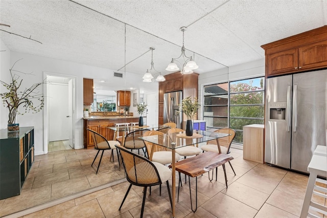 2424 W Tampa Bay Blvd Unit G204, Tampa, FL 33607 - dining room featuring a textured ceiling, light tile patterned floors, and a chandelier