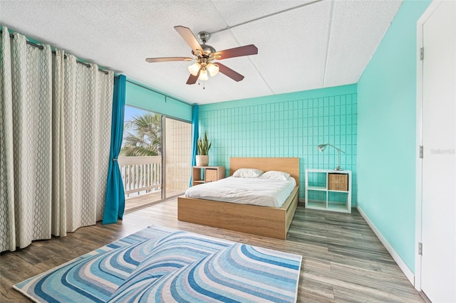 2424 W Tampa Bay Blvd Unit G204, Tampa, FL 33607 - bedroom featuring access to outside, wood finished floors, a ceiling fan, and a textured ceiling