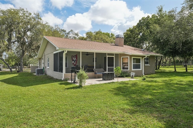 10614 Hudson Ave, Hudson, FL 34669 - rear view of house featuring a patio, a chimney, a lawn, and a ceiling fan