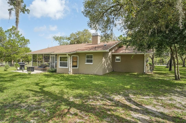 10614 Hudson Ave, Hudson, FL 34669 - back of property with stucco siding, a chimney, a sunroom, and a yard