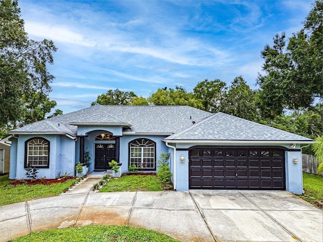 22946 Brownwood Ct, Land O Lakes, FL 34639 - ranch-style house with a garage, concrete driveway, roof with shingles, and stucco siding