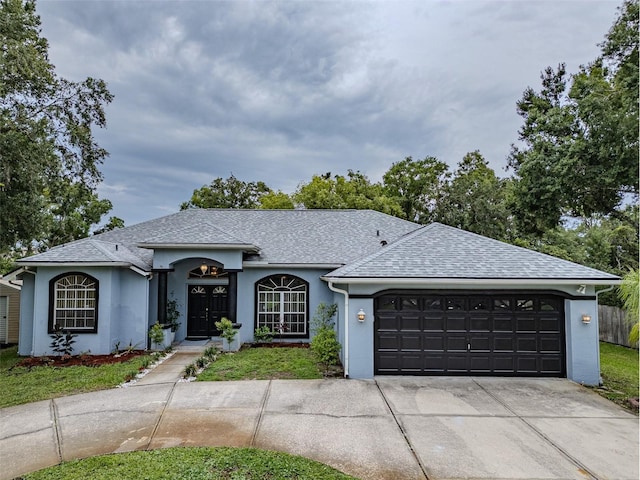 22946 Brownwood Ct, Land O Lakes, FL 34639 - ranch-style home featuring an attached garage, a shingled roof, driveway, and stucco siding