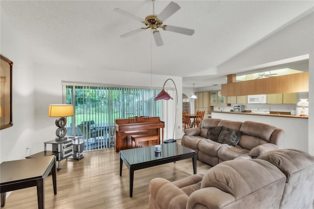 22946 Brownwood Ct, Land O Lakes, FL 34639 - living room with lofted ceiling, a ceiling fan, light wood-type flooring, and a textured ceiling