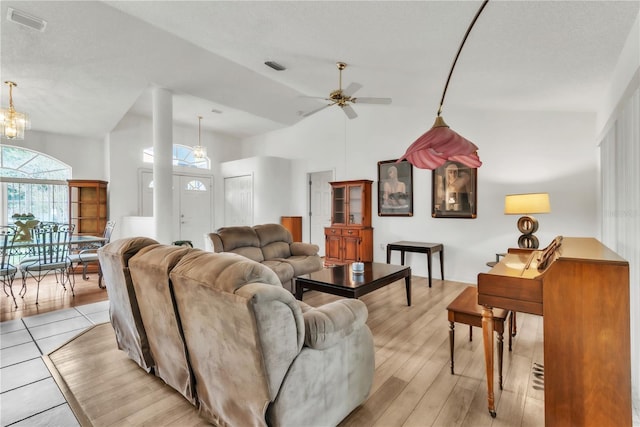 22946 Brownwood Ct, Land O Lakes, FL 34639 - living room with ceiling fan, light wood-style flooring, a high ceiling, and a chandelier