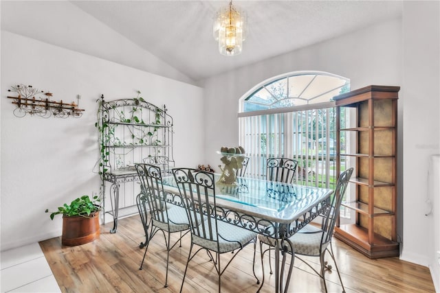 22946 Brownwood Ct, Land O Lakes, FL 34639 - dining room featuring light wood finished floors, vaulted ceiling, and a chandelier